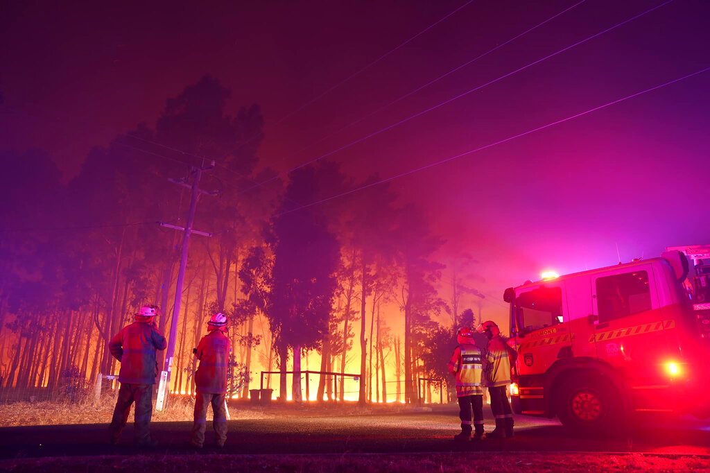 Firefighters attend a fire at Wooroloo, near Perth, Australia, Monday, Feb. 1, 2021. An out-of-control wildfire burning northeast of the Australian west coast city of Perth has destroyed an estimated 30 homes and was threatening more Tuesday, with many locals across the region told it is too late to leave. (Evan Collis/DFES via AP)