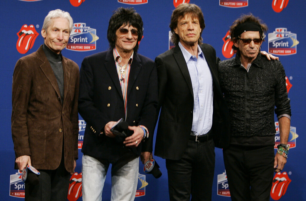 FILE - Members of the Rolling Stones, from left, drummer Charlie Watts, guitarist Ron Wood, singer Mick Jagger, and guitarist Keith Richards. pose for photographers after arriving for a Super Bowl news conference in Detroit on Feb. 2, 2006. Watts' publicist, Bernard Doherty, said Watts passed away peacefully in a London hospital surrounded by his family on Tuesday, Aug. 24, 2021. He was 80.  The Rolling Stones were the halftime entertainment at Super Bowl XL foorball game between Pittsburgh Steelers and the Seattle Seahawks.    (AP Photo/Michael Conroy, File)
