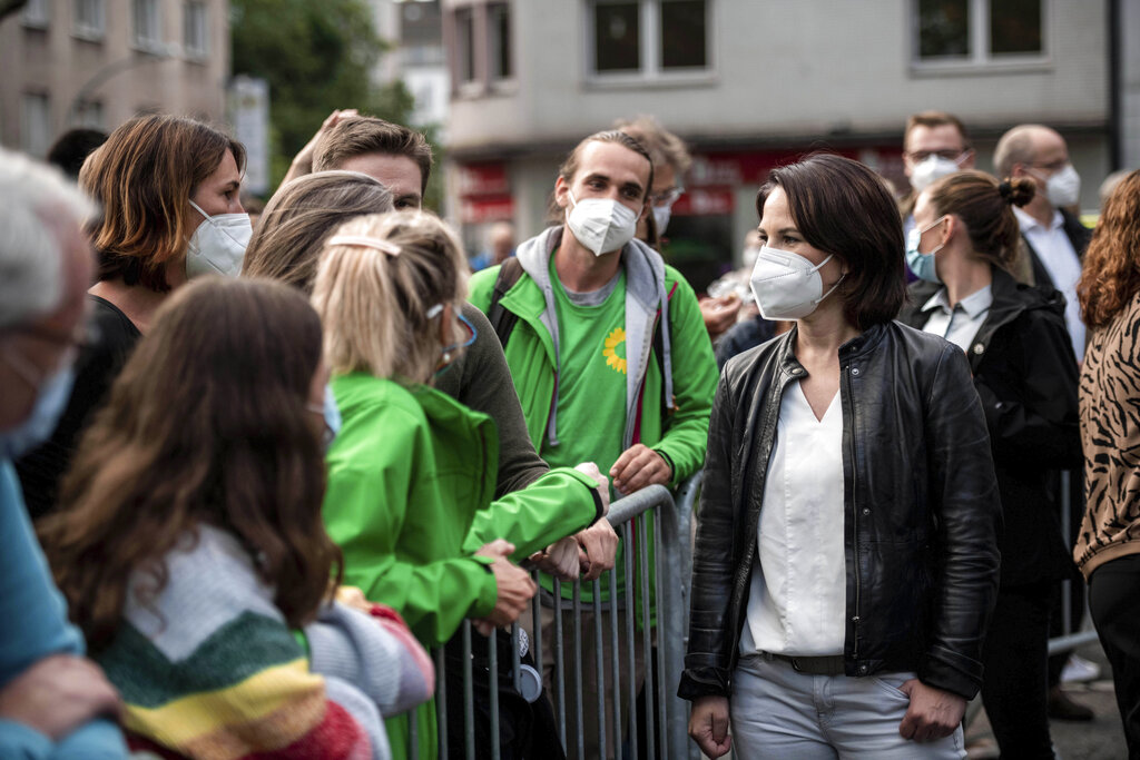 Annalena Baerbock, second right, candidate for chancellor and federal chairwoman of Greens, talks to citizens and party friends at a campaign event of the Greens for the Bundestag elections at Ludgeriplatz, in Duisburg, Germany, Tuesday, Aug. 10, 2021. (Fabian Strauch/dpa via AP)