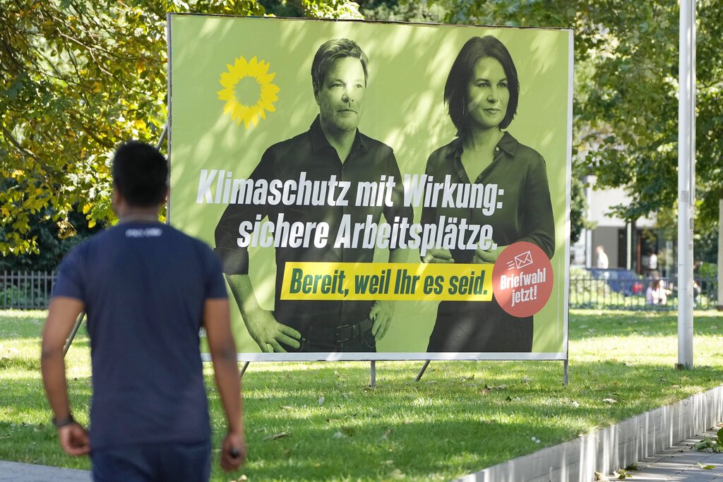 An election poster for the Green Party shows top candidate Annalena Baerbock and party co-chairman Robert Habeck at a street in Duesseldorf, Germany, Wednesday, Aug. 25, 2021. A large chunk of the German electorate remains undecided going into an election that will determine who succeeds Angela Merkel as chancellor after 16 years in power. Recent surveys show that support for German political parties has flattened out, with none forecast to receive more than a quarter of the vote. (AP Photo/Martin Meissner)
