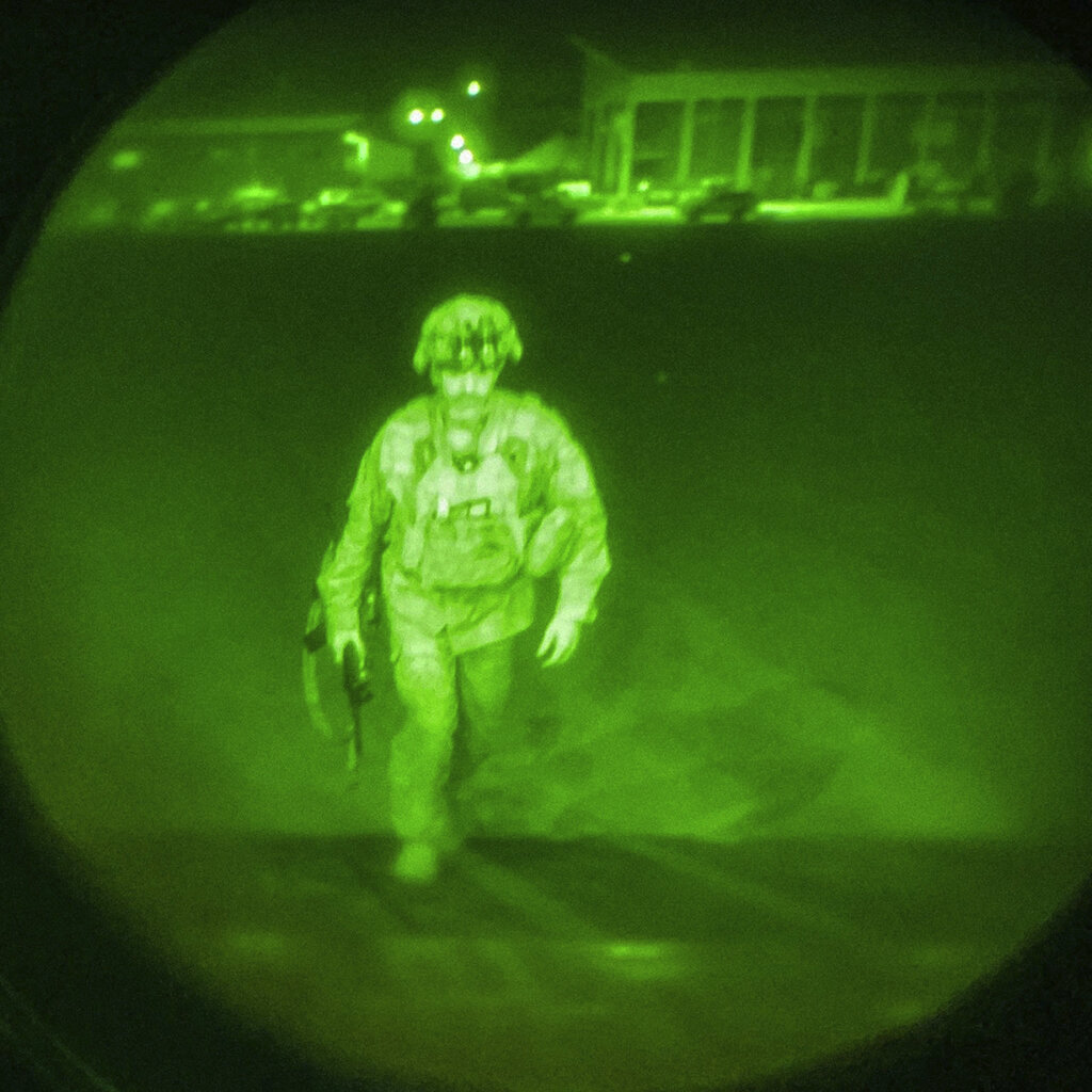 In this image made through a night vision scope and provided by U.S. Central Command, Maj. Gen. Chris Donahue, commander of the U.S. Army 82nd Airborne Division, XVIII Airborne Corps, boards a C-17 cargo plane at Hamid Karzai International Airport in Kabul, Afghanistan, Monday, Aug. 30, 2021, as the final American service member to depart Afghanistan. (U.S. Central Command via AP)
