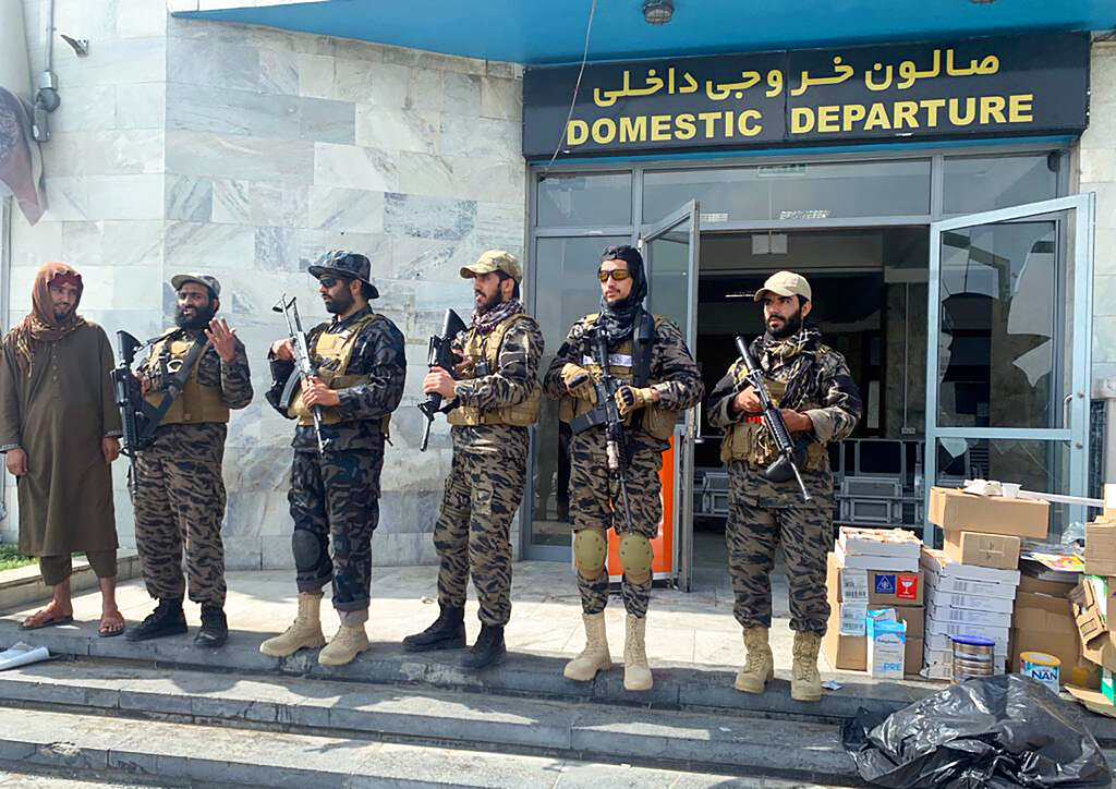 Taliban fighters stand guard inside the Hamid Karzai International Airport after the U.S. withdrawal in Kabul, Afghanistan, Tuesday, Aug. 31, 2021. The Taliban were in full control of Kabul's international airport on Tuesday, after the last U.S. plane left its runway, marking the end of America's longest war. (AP Photo/Kathy Gannon)