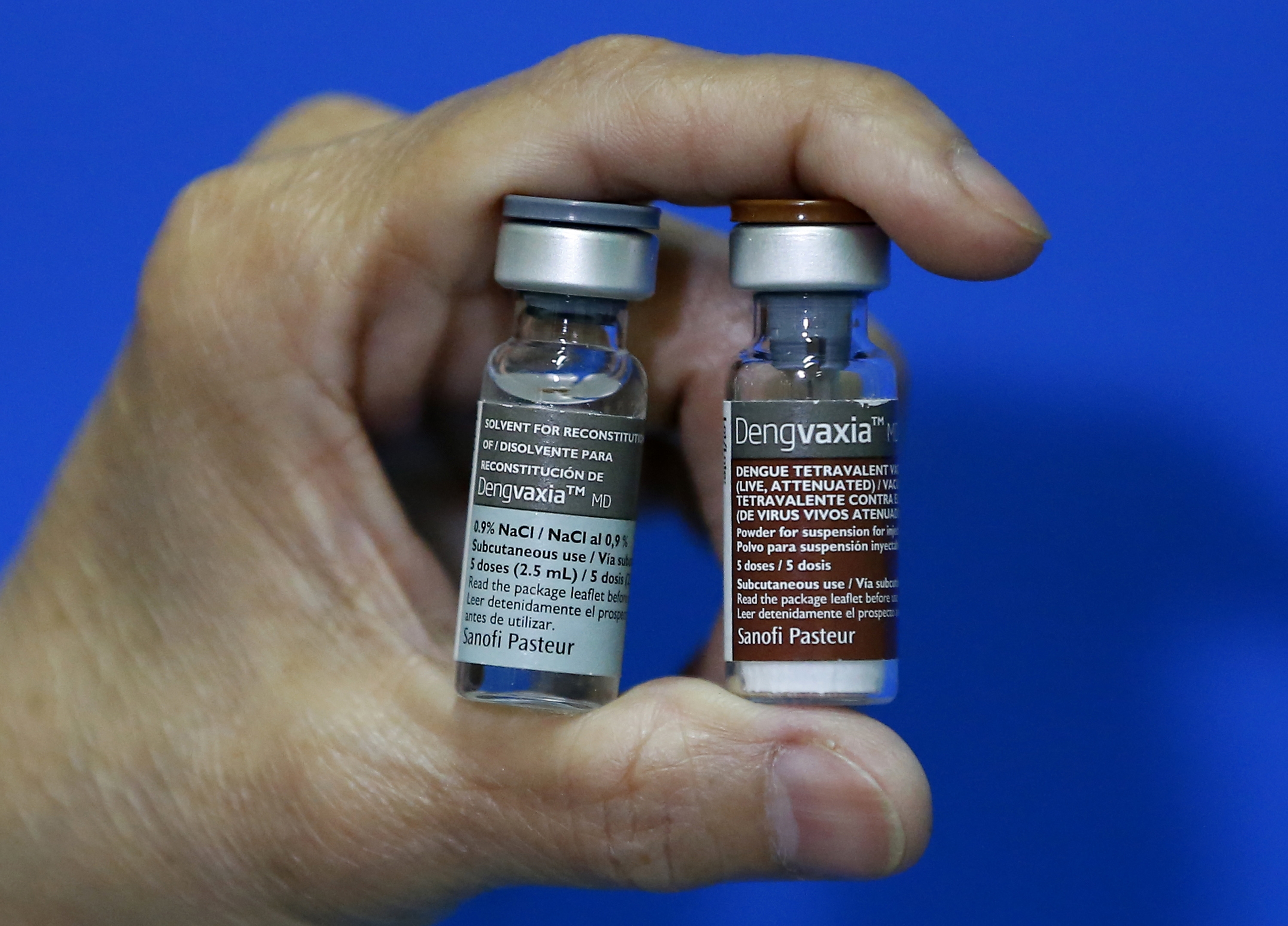 A Manila Health offricer displays a pair of vials of the anti-dengue vaccine Dengvaxia after being recalled from local government health centers Tuesday, Dec. 5, 2017 in Manila, Philippines. The controversial vaccine, manufactured by Sanofi Pasteur and administered to more than 700,000 Filipino children, was put on hold by the Philippines last week after new study findings showed it posed risks of severe cases in people without previous infection. (AP Photo/Bullit Marquez)