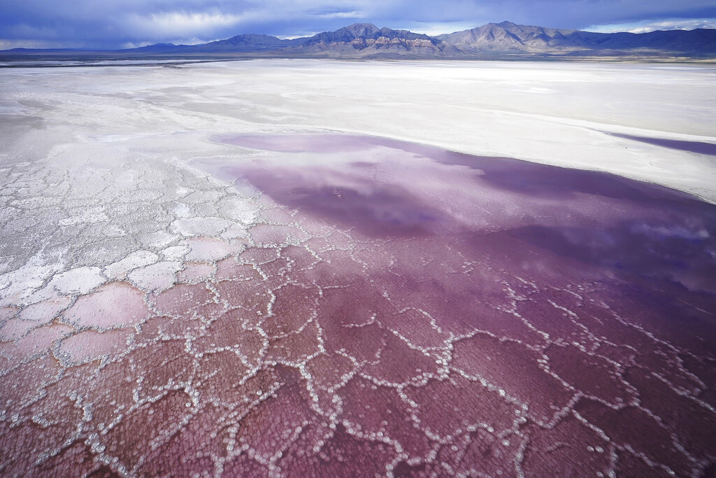 Pink water washes over a salt crust on May 4, 2021, along the receding edge of the Great Salt Lake. The lake has been shrinking for years, and a drought gripping the American West could make this year the worst yet. (AP Photo/Rick Bowmer)