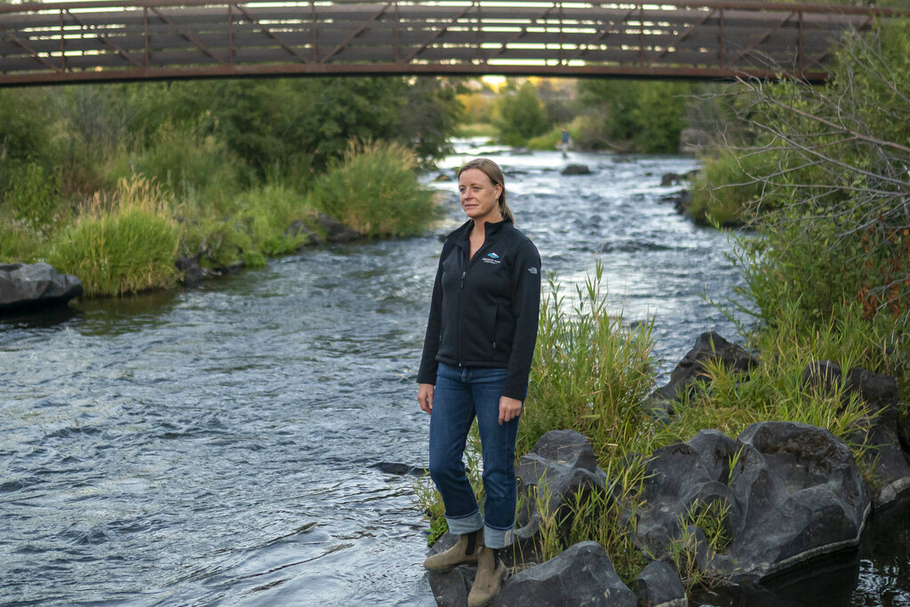 Kate Fitzpatrick, the executive director of the Deschutes River Conservancy, poses for a press photo along the banks of the middle Deschutes River on Tuesday, Aug. 31, 2021, in Bend, Ore. (AP Photo/Nathan Howard)