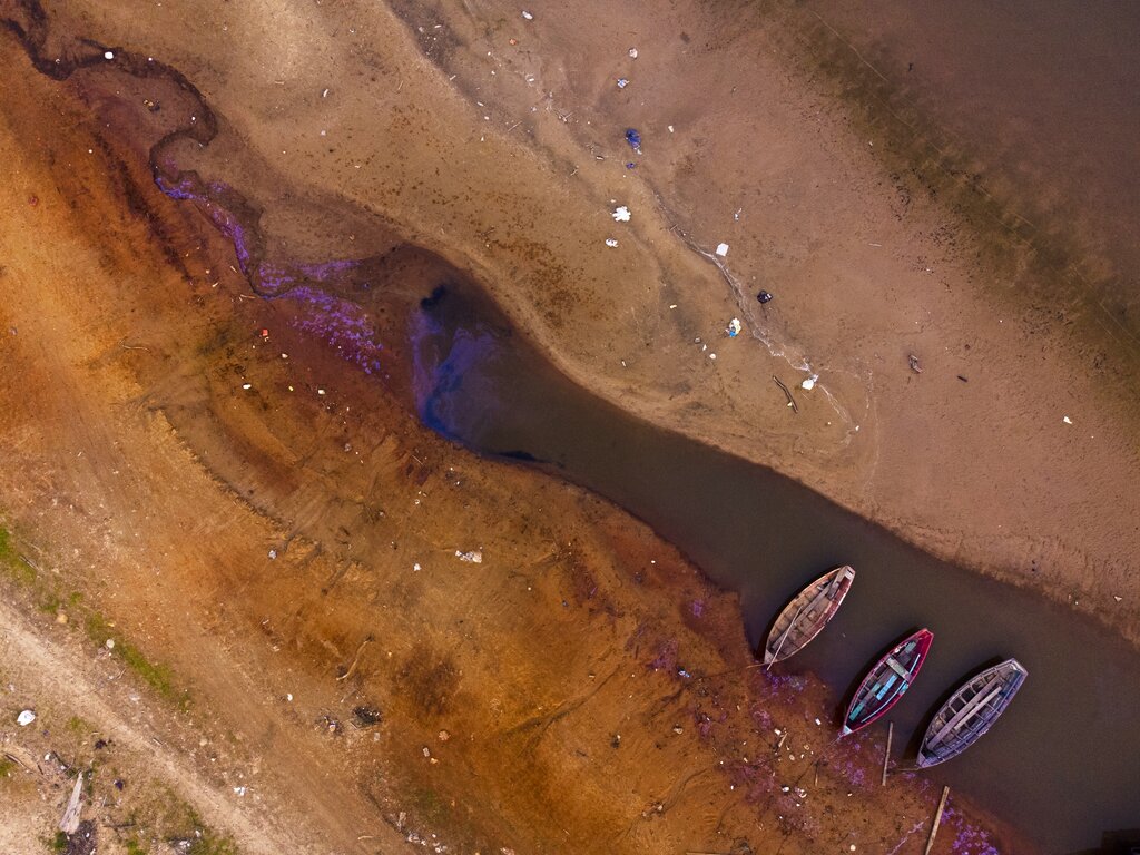 Boats languish over the last pools of water available on the Payagua stream that reaches the Paraguay river amid a historic drought that is affecting its levels, in Chaco-i, Paraguay, Monday, Sept. 20, 2021. (AP Photo/Jorge Saenz)