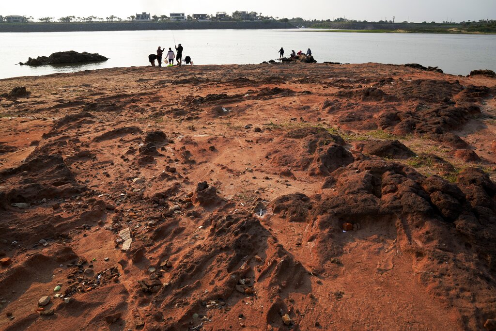 Families fish on the exposed bed of the Paraguay river, amid a historic drought that is affecting the river´s  level, in Mariano Roque Alonso, Paraguay, Monday, Sept. 20, 2021. (AP Photo/Jorge Saenz)