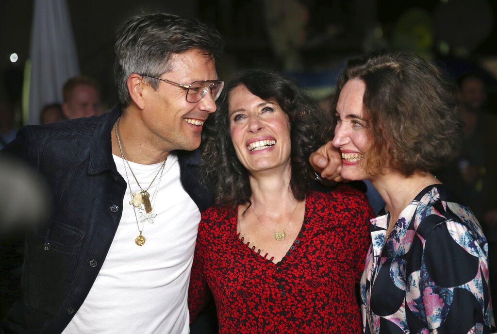 Berlin mayoral candidate Bettina Jarasch of the Green Party, center, is joined by her husband Oliver Jarasch and her sister Judith Hartmann arrives at an election party in Berlin after parliamentary elections Sunday Sept. 26, 2021. (Christoph Soeder/dpa via AP)