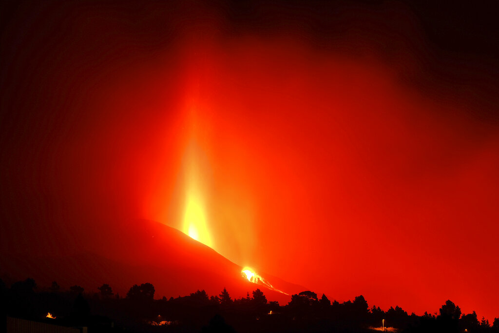 Lava flows from a volcano on the Canary island of La Palma, Spain on Sunday Sept. 26, 2021. A massive cloud of ash prevented flights in and out of the Spanish island of La Palma on Sunday as molten rock continued to be flung high into the air from an erupting volcano. (AP Photo/Daniel Roca)