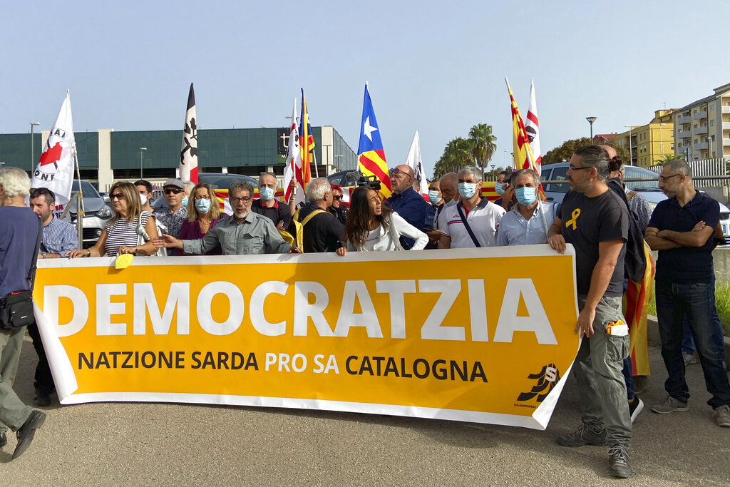 Demonstrators hold a banner with writing reading in a Sardinian dialect, ”Democracy, the Sardinian nation supports the Catalan nation