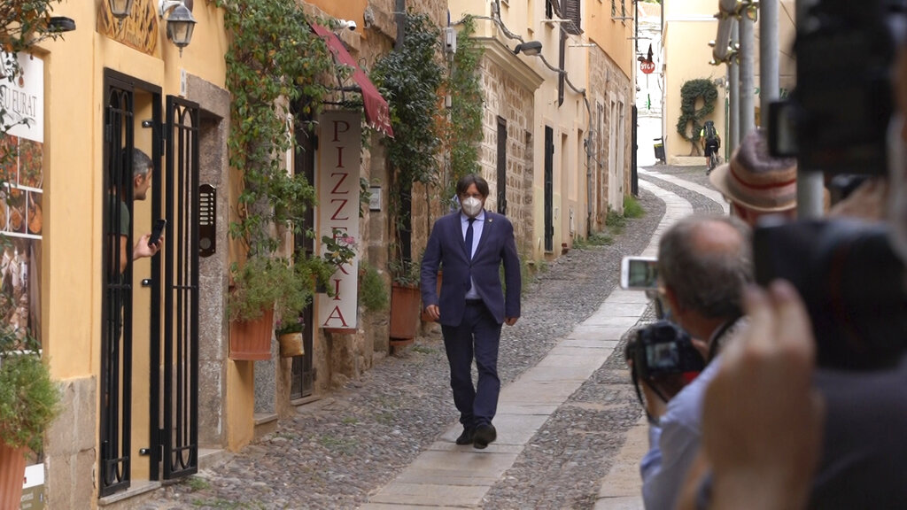 Catalan separatist leader Carles Puigdemont walks in a street of the Sardinian city of Alghero, Italy, Saturday, Sept. 25, 2021, a day after a judge freed him from jail pending a hearing on his extradition to Spain, where the political firebrand is wanted for sedition. (AP Photo/Andrea Rosa)