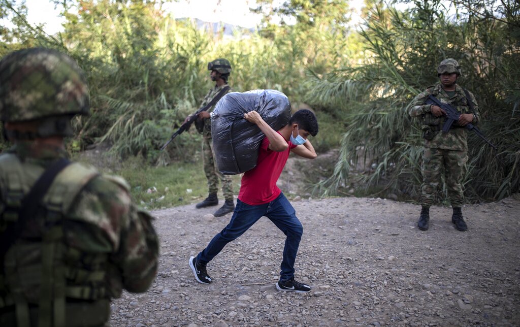 A man crosses illegally from Colombia to Venezuela in La Parada, Colombia, Tuesday, Oct. 5, 2021. Venezuela partially reopened its border with Colombia after closing it on 2019, a nearly three-year closure due to political tensions. (AP Photo/Ivan Valencia)