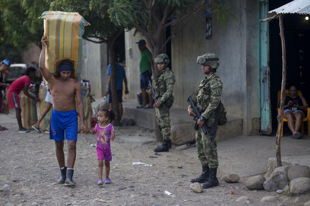 A man and a girl cross illegally into Colombia from Venezuela, near the Simon Bolivar International Bridge in La Parada near Cucuta, Colombia,  Colombia, Tuesday, Oct. 5, 2021. Venezuela partially reopened its border with Colombia after closing it on 2019, a nearly three-year closure due to political tensions. (AP Photo/Ivan Valencia)