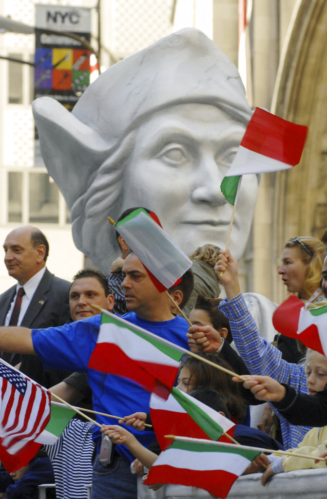 FILE - In this Oct. 9, 2006, file photo, parade-goers wave Italian and American flags in front of a giant bust of Christopher Columbus as it rides on the Columbus Citizens Foundation float as part of Columbus Day Parade along Fifth Avenue in New York. A movement to abolish Columbus Day and replace it with Indigenous Peoples Day has new momentum but the gesture to recognize victims of European colonialism has also prompted howls of outrage from some Italian Americans, who say eliminating their festival of ethnic pride is culturally insensitive, too. (AP Photo/Henny Ray Abrams, File)