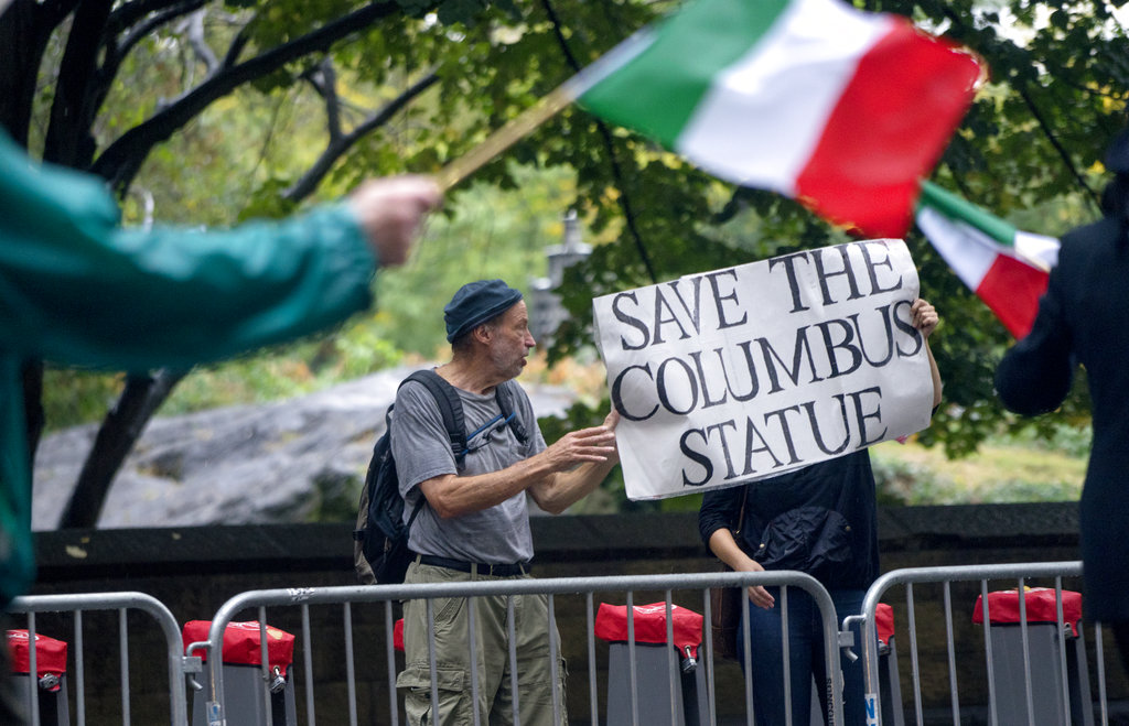 Activists standing along 5th Avenue in New York display a sign in favor of keeping the statue of Christopher Columbus during the annual Columbus Day Parade on Monday, Oct. 9, 2017. (AP Photo/Craig Ruttle)