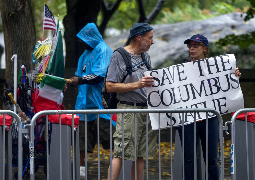 Activists standing along 5th Avenue in New York display a sign in favor of keeping the statue of Christopher Columbus during the annual Columbus Day Parade on Monday, Oct. 9, 2017. (AP Photo/Craig Ruttle)