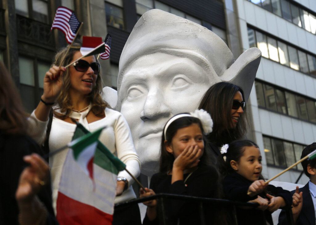 FILE - In this Oct. 12, 2015, file photo, participants in New York's Columbus Day Parade ride a float with a large bust of Columbus. The New York City public school system has designated Oct. 11 as Italian Heritage Day/Indigenous People's Day, in an effort to please both Italian Americans who celebrate Christopher Columbus and racial justice advocates who accuse him of genocide. (AP Photo/Seth Wenig, File)
