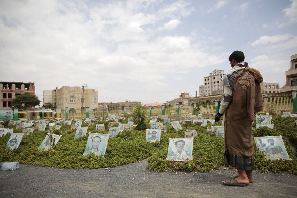 A war-disabled Houthi supporter offers prayers at the grave of his relative who was killed during recent fighting, at a cemetery in Sanaa, Yemen, Wednesday, Sept. 29, 2021. Two days of fierce clashes between Yemeni government forces and Houthi rebels over a crucial central city have killed more than 130 fighters, mostly rebels, officials said Tuesday. (AP Photo/Hani Mohammed)