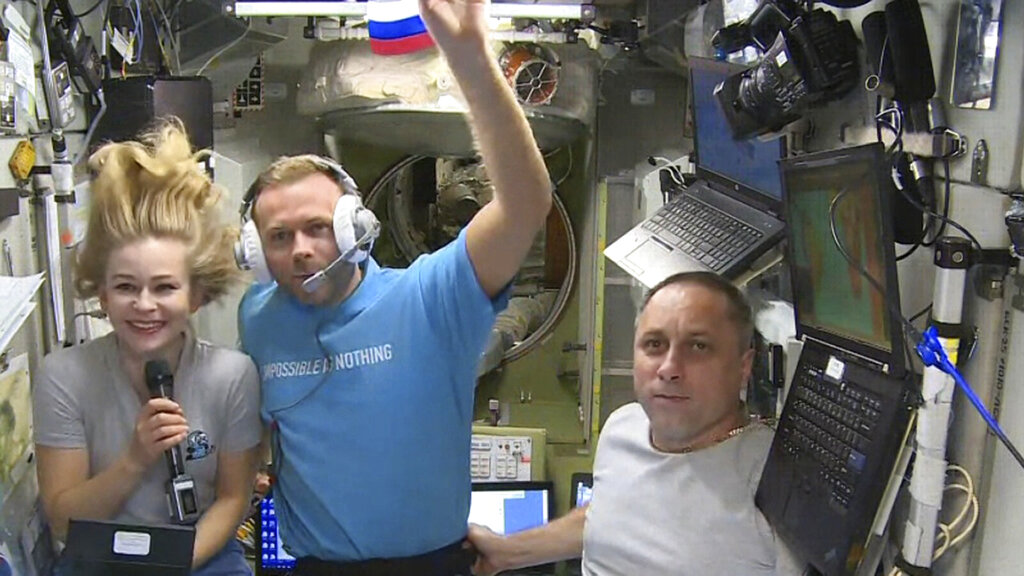 In this photo taken from video footage released by Roscosmos Space Agency, actress Yulia Peresild, left, film director Klim Shipenko, center, and cosmonaut Anton Shkaplerov speak with the Moscow Mission Control Center from the International Space Station, ISS, Thursday, Oct. 7, 2021. Actress Yulia Peresild and film director Klim Shipenko blasted off Tuesday for the International Space Station in a Russian Soyuz spacecraft together with cosmonaut Anton Shkaplerov, a veteran of three space missions, to make a feature film in orbit. (Roscosmos Space Agency via AP)