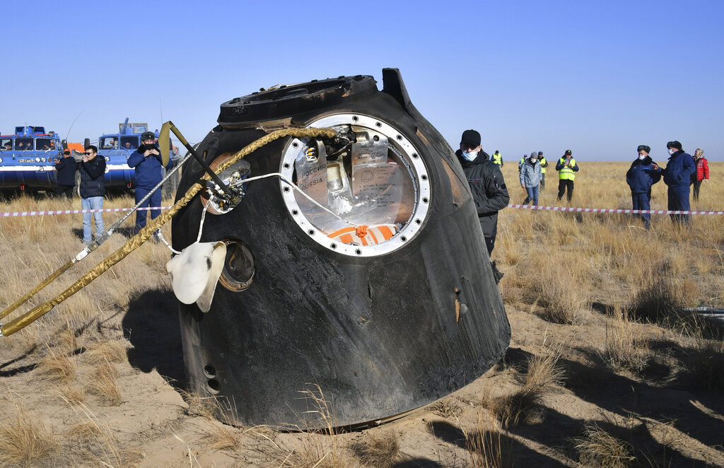 In this photo released by the Roscosmos Space Agency, the Russian Soyuz MS-18 space capsule stands on the ground shortly after the landing of about 150 km (90 miles) south-east of the Kazakh town of Zhezkazgan, Kazakhstan, Sunday, Oct. 17, 2021. The Soyuz MS-18 capsule landed upright in the steppes of Kazakhstan on Sunday with cosmonaut Oleg Novitskiy, actress Yulia Peresild and film director Klim Shipenko aboard after a 3 1/2-hour trip from the International Space Station. (Pavel Kassin, Roscosmos Space Agency via AP)