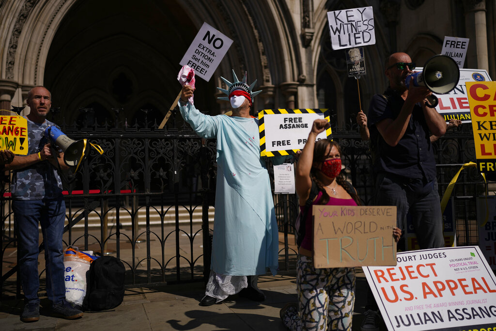 A supporter of WikiLeaks founder Julian Assange demonstrates dressed as the Statue of Liberty, during the first hearing in the Julian Assange extradition appeal, at the High Court in London, Wednesday, Aug. 11, 2021. Britain's High Court has granted the U.S. government permission to appeal a decision that WikiLeaks founder Julian Assange cannot be sent to the United States to face espionage charges. (AP Photo/Matt Dunham)