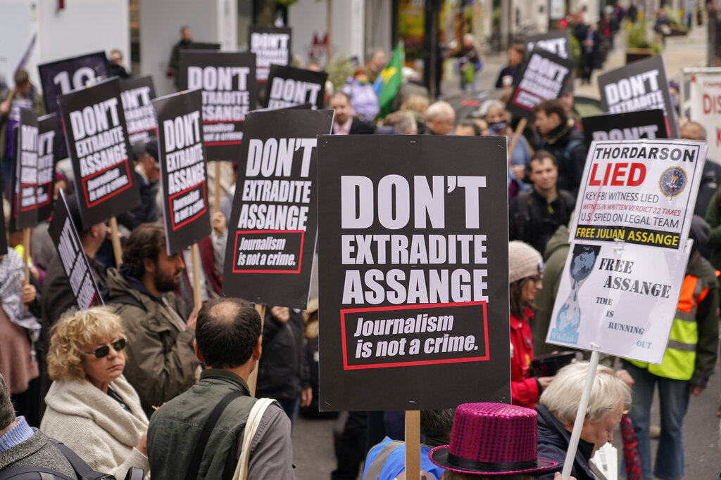 Supporters of WikiLeaks founder Julian Assange hold placards and take part in a march in London, Saturday, Oct. 23, 2021, ahead of next week's extradition case appeal. (AP Photo/Alberto Pezzali)