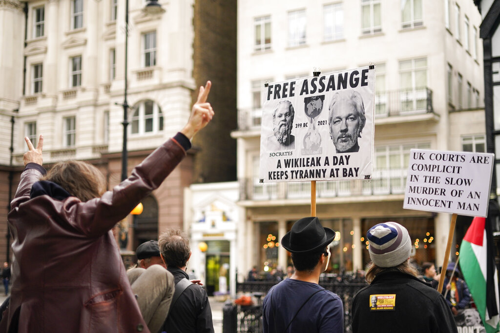 Supporters of WikiLeaks founder Julian Assange hold placards as they gather outside the Royal Courts of Justice, in London, Saturday, Oct. 23, 2021, ahead of next week's extradition case appeal. (AP Photo/Alberto Pezzali)