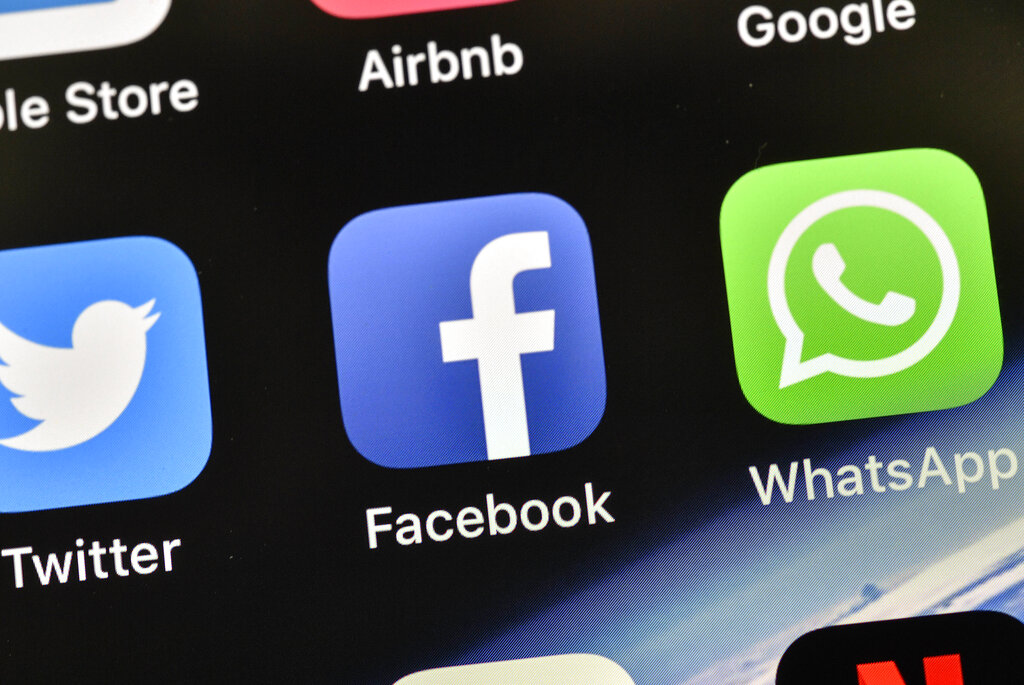 FILE - In this Nov. 15, 2018 file photo, the icons of Facebook and WhatsApp are pictured on an iPhone, in Gelsenkirchen, Germany. Last spring, as false claims about vaccine safety threatened to undermine the world's response to COVID-19, researchers at Facebook wrote that they could reduce vaccine misinformation by tweaking how vaccine posts show up on users' newsfeeds, or by turning off comments entirely. Yet despite internal documents showing these changes worked, Facebook was slow to take action. (AP Photo/Martin Meissner, File)