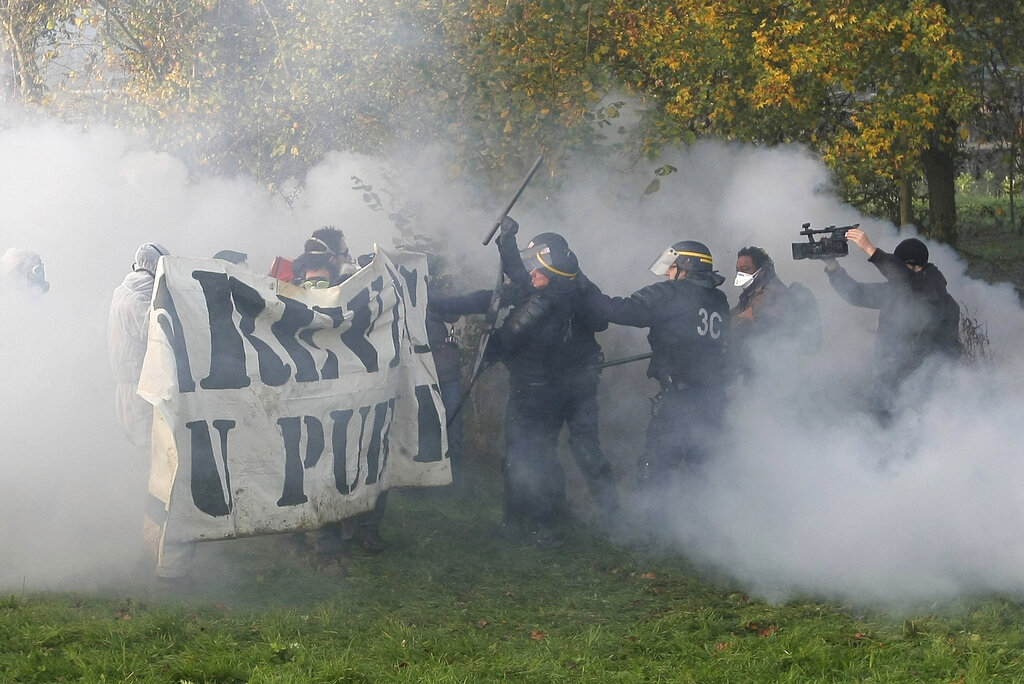 FILE - A group of activists clash with riot police officers early Wednesday, Nov. 23, 2011, in Lieusaint, Normandy, France, as they try to block the train tracks in an effort to stop a train loaded with nuclear waste and heading to Gorleben in Germany. Nuclear power is a central sticking point as negotiators plot out the world’s future energy strategy at the climate talks in Glasgow, Scotland. Critics decry its mammoth price tag, the disproportionate damage caused by nuclear accidents and radioactive waste. But a growing pro-nuclear camp argues that it’s safer on average than nearly any other energy source. (AP Photo/David Vincent, File)