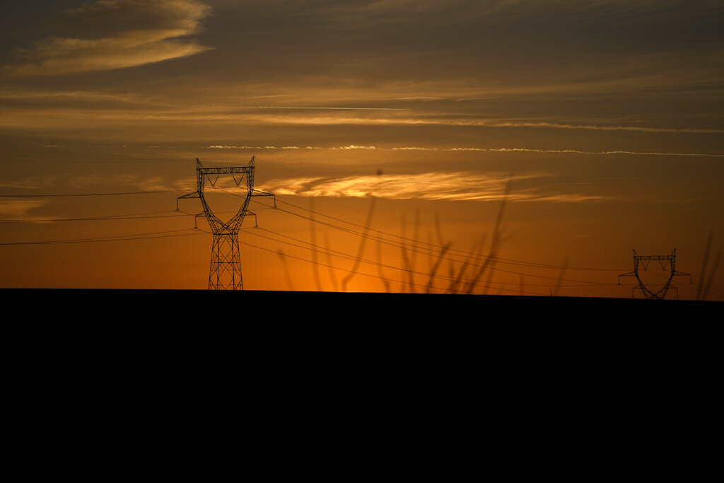 The sun sets on electricity pylons next to an underground laboratory run by French radioactive waste management agency Andra, in Bure, eastern France, Thursday, Oct. 28, 2021. (AP Photo/Francois Mori)