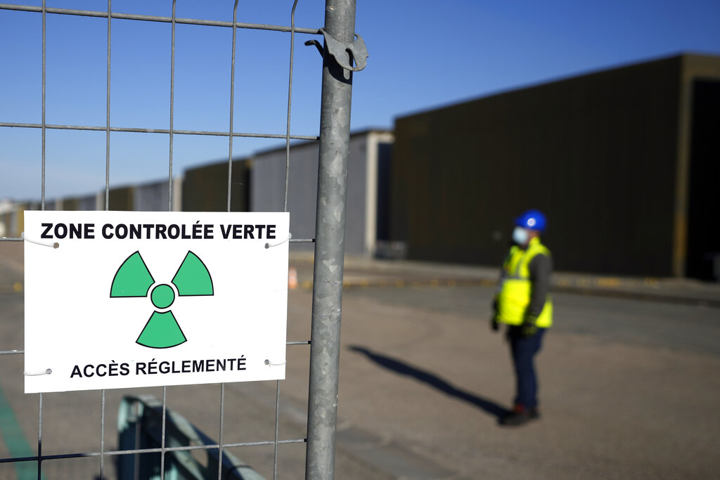 A technician stands next to a radioactive waste storage zone along a concrete-sealed warehouse in the Aube region of eastern France in Soulaines-Dhuys, Friday, Oct. 29, 2021. The site holds low- to mid-level radioactive waste from French nuclear plants as well as research and medical facilities, and its concrete-sealed warehouses are designed to store the waste for at least 300 years. (AP Photo/Francois Mori)