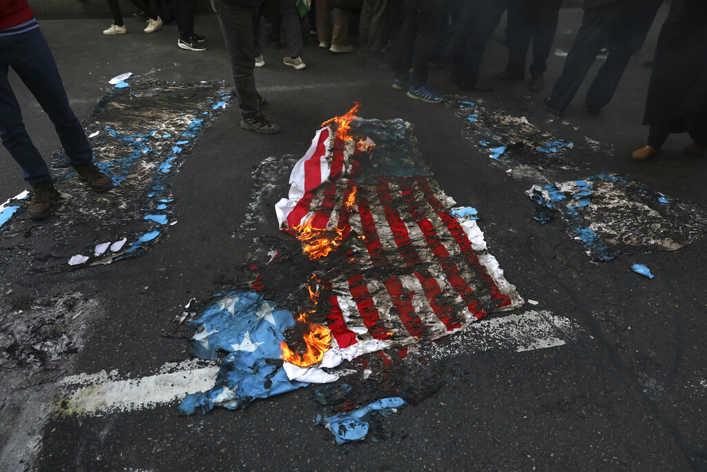 A mock U.S. flag is set on fire by demonstrators in a rally in front of the former U.S. Embassy commemorating the anniversary of its 1979 seizure in Tehran, Iran, Thursday, Nov. 4, 2021. The embassy takeover triggered a 444-day hostage crisis and break in diplomatic relations that continues to this day. (AP Photo/Vahid Salemi)