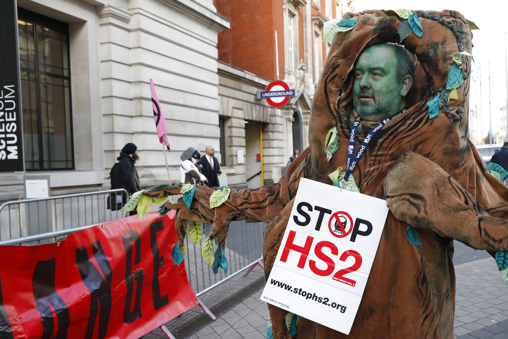 A climate change protester demonstrates outside the Science Museum where the British Prime Minister Boris Johnson and his Italian counterpart Giuseppe Conte attend the launch of the next UN Climate Change conference COP26, London, Tuesday, Feb. 4, 2020. COP26 will be held in Glasgow, Scotland in November. (AP Photo/Alastair Grant)