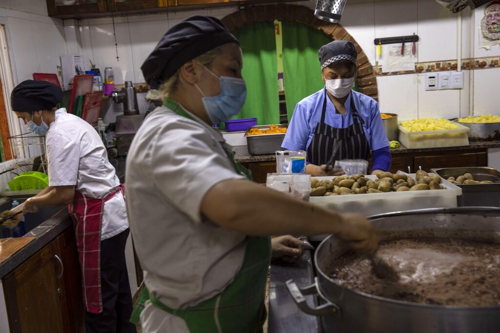 Women prepare lunch in the El Alfarero popular dining room, in Buenos Aires, Argentina, Tuesday, Nov. 9, 2021. In the midst of a severe economic crisis, legislative elections are scheduled for Nov. 14. (AP Photo/Rodrigo Abd)
