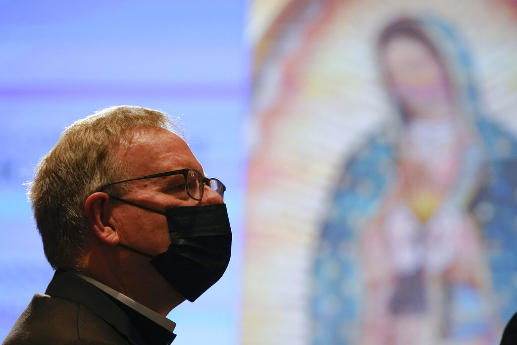 An image of Our Lady of Guadalupe is seen as a bishop wears a mask to protect the spread of COVID-19 during the Fall General Assembly meeting of the United States Conference of Catholic Bishops, Tuesday, Nov. 16, 2021, in Baltimore.(AP Photo/Julio Cortez)