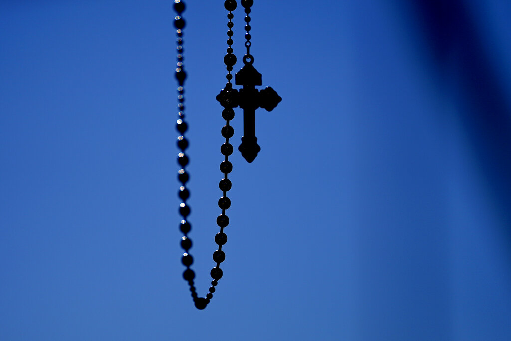 A Rosary is seen as people pray during a rally outside of the Baltimore hotel where the United States Conference of Catholic Bishops are holding its Fall General Assembly meeting, Tuesday, Nov. 16, 2021, in Baltimore. (AP Photo/Julio Cortez)