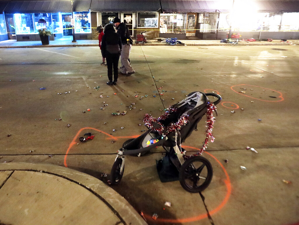 A broken children's stroller lays on W. Main St. in downtown Waukesha, Wis., after an SUV drove into a parade of Christmas marchers Sunday, Nov. 21, 2021. (John Hart/Wisconsin State Journal via AP)