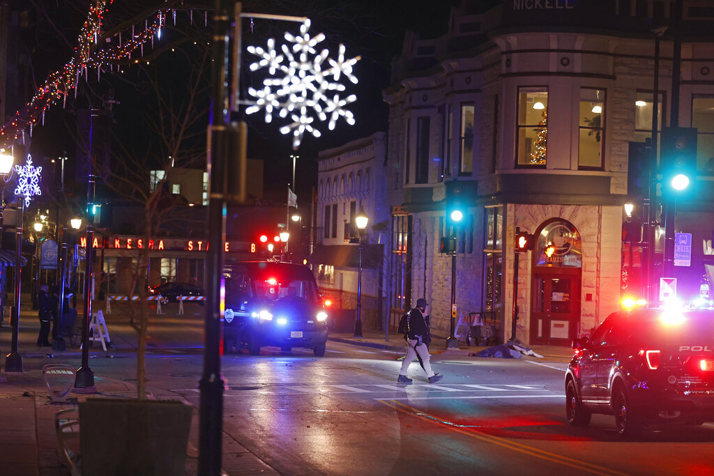Police canvass the streets in downtown Waukesha, Wis., after a vehicle plowed into a Christmas parade hitting more than 20 people Sunday, Nov. 21, 2021. (AP Photo/Jeffrey Phelps)