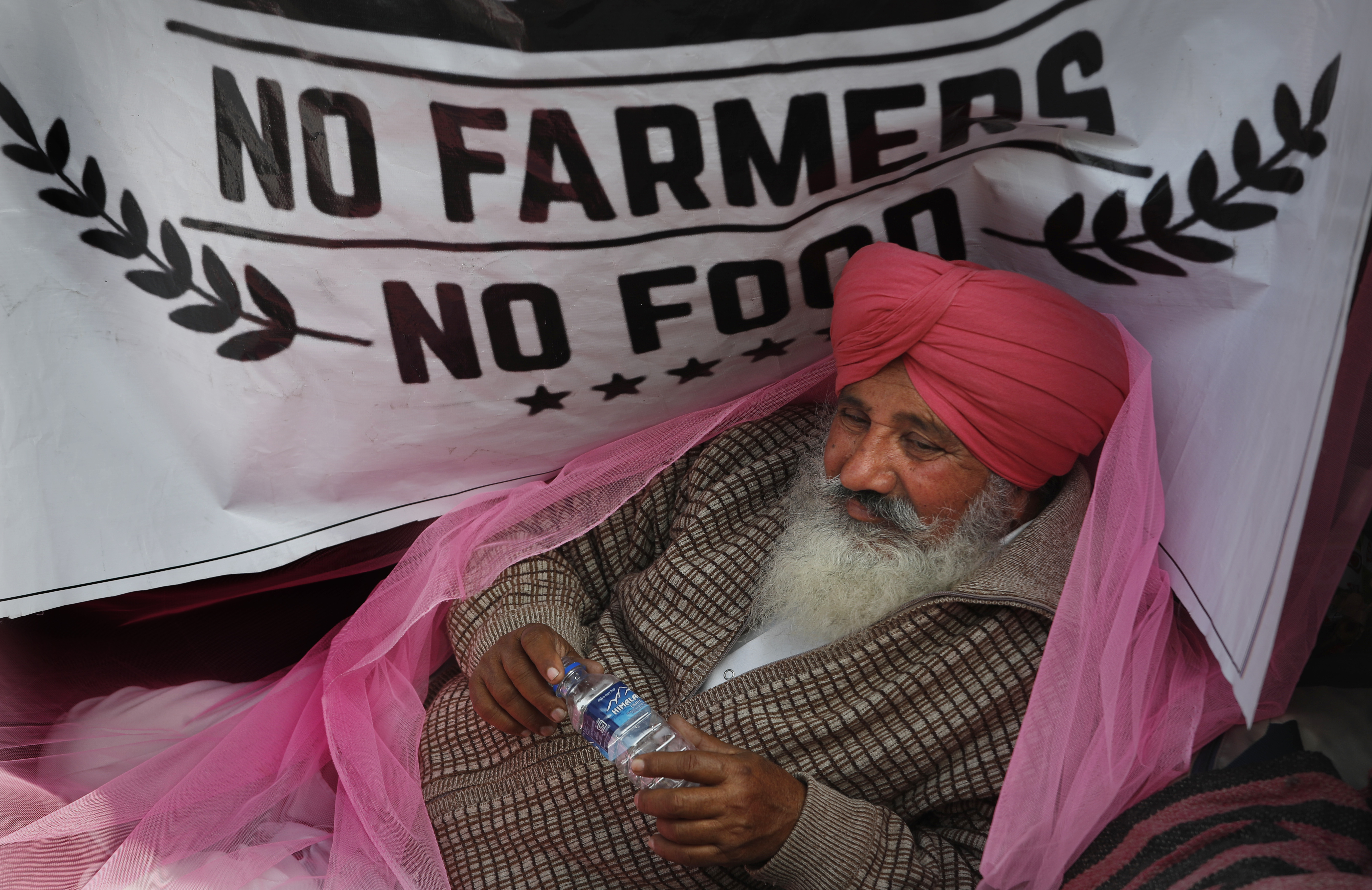 FILE - In this Monday, Dec. 14, 2020, file photo, a protesting farmer rests on his tractor trailer blocking a highway with other farmers at the Delhi- Haryana border, on the outskirts of New Delhi, India. Relations between Twitter and Modi's government have gone downhill ever since a tweet by pop star Rihanna in February sparked widespread condemnation of Indian Prime Minister Narendra Modi’s handling of massive farmer protests near the capital. At the heart of the standoff is a sweeping internet law that puts digital platforms like Twitter and Facebook under direct government oversight. Critics of the law worry it may lead to outright censorship in a country where digital freedoms have been shrinking since Modi took office in 2014. (AP Photo/Manish Swarup, File)