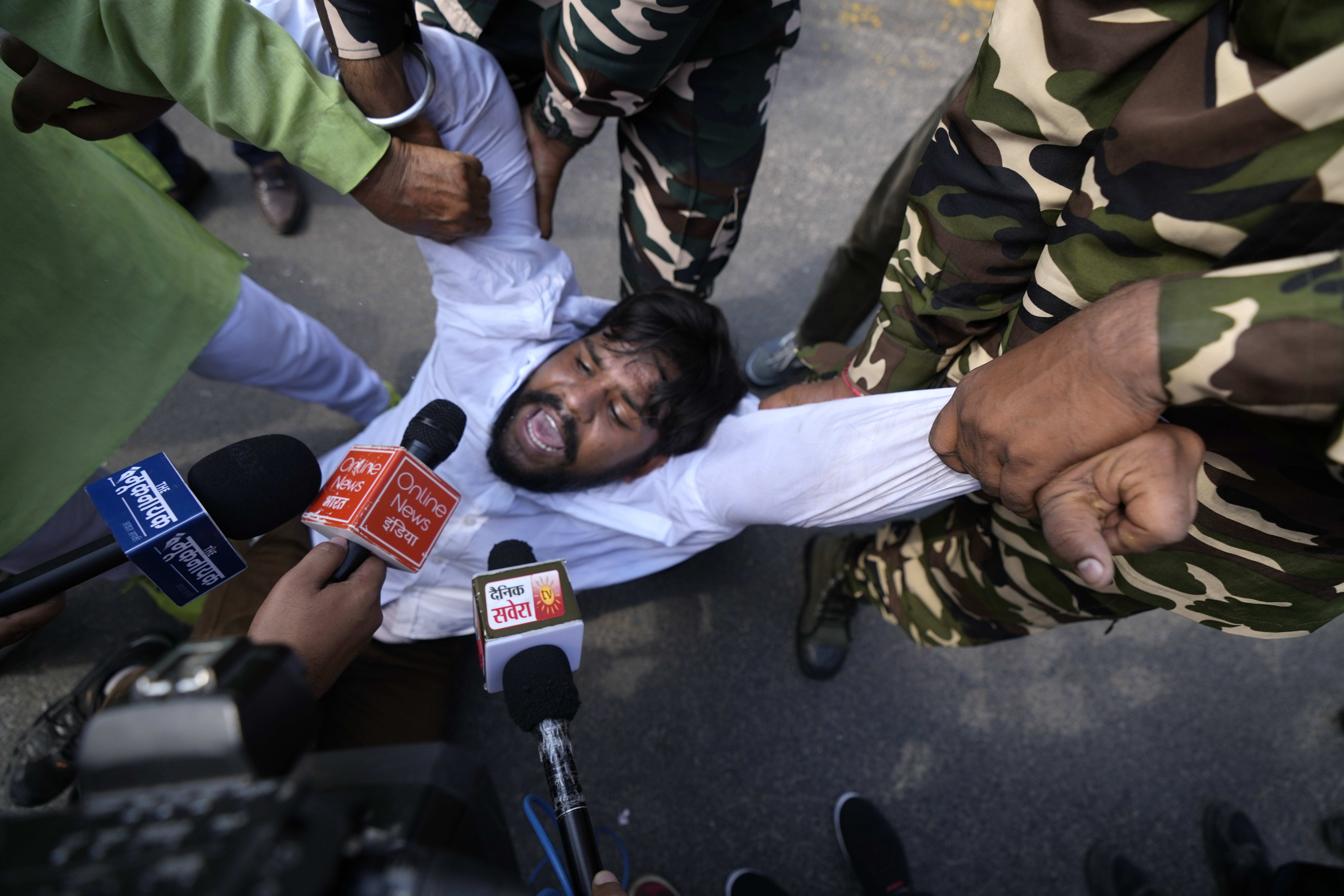 Paramilitary force soldiers detain an activist of Congress party's youth wing protesting against Sunday's killing of four farmers in Uttar Pradesh state after being run over by a car owned by India's junior home minister in New Delhi, India, Monday, Oct. 4, 2021. Indian authorities suspended internet services and barred political leaders from entering a northern town Monday to calm tensions after nine people were killed in a deadly escalation of a yearlong demonstration against contentious agriculture laws. (AP Photo/Manish Swarup)