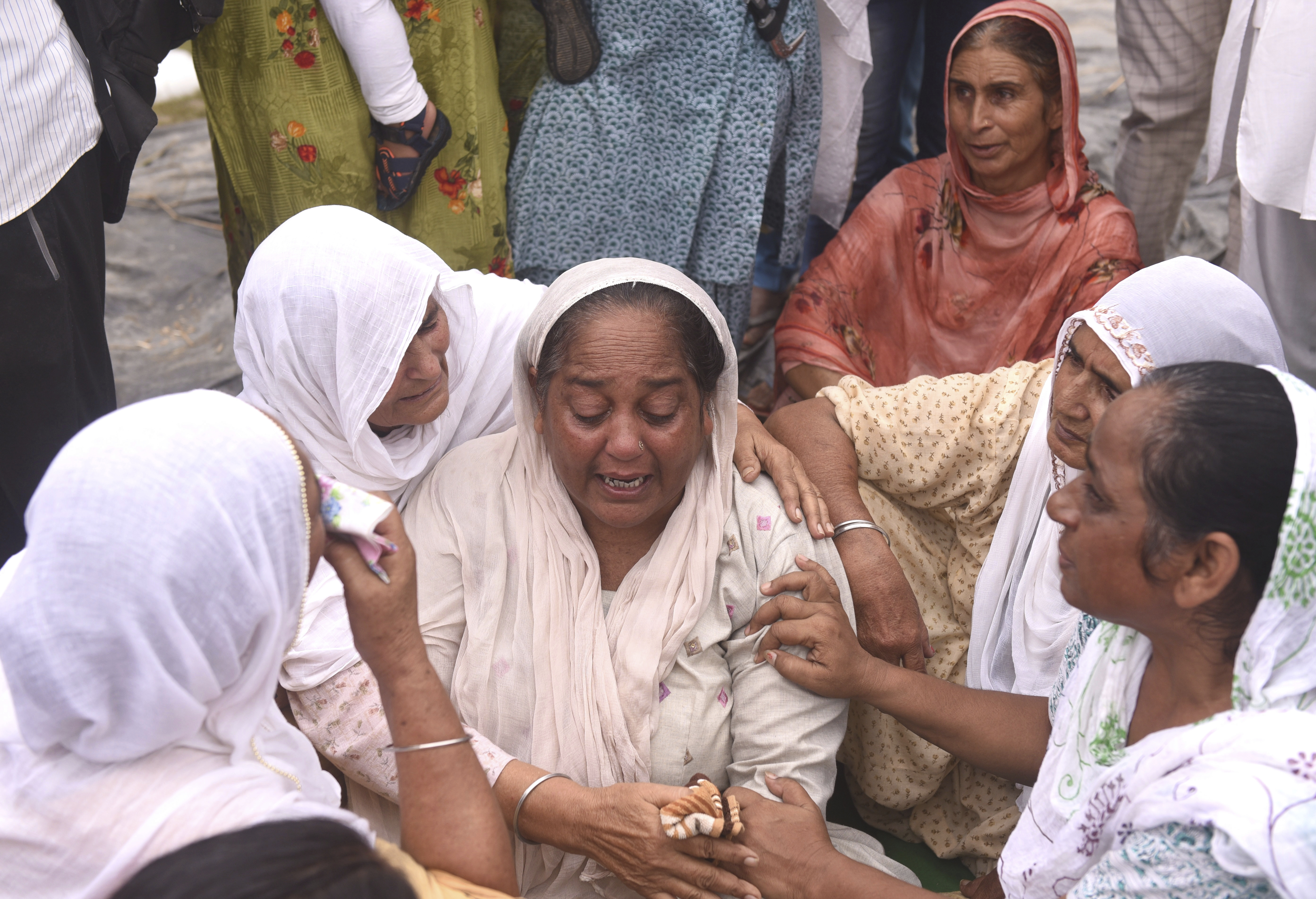 Relatives and neighbors of a farmer who was killed Sunday after being run over by a car owned by India's junior home minister mourn at Tikonia village in Lakhimpur Kheri, Uttar Pradesh state, India, Monday, Oct. 4, 2021. Indian police on Saturday, Oct. 9, arrested the son of a junior minister in Prime Minister Narendra Modi’s government as a suspect days after nine people were killed in a deadly escalation of yearlong demonstrations by tens of thousands of farmers against contentious agriculture laws in northern India, a police officer said. (AP Photo)