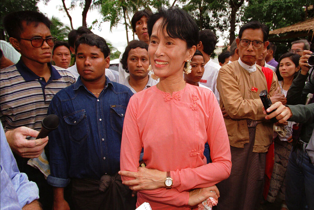 FILE - Burmese pro-democracy leader of the NLD (National League for Democracy) Aung San Suu Kyi, center, answers reporters' questions after a news conference at her residence in Rangoon, Burma on May 23, 1996. A court in Myanmar sentenced the country’s ousted leader, Aung San Suu Kyi, to four years in prison on Monday, Dec. 6, 2021, after finding her guilty of incitement and violating coronavirus restrictions, a legal official said. (AP Photo/Richard Vogel, File)