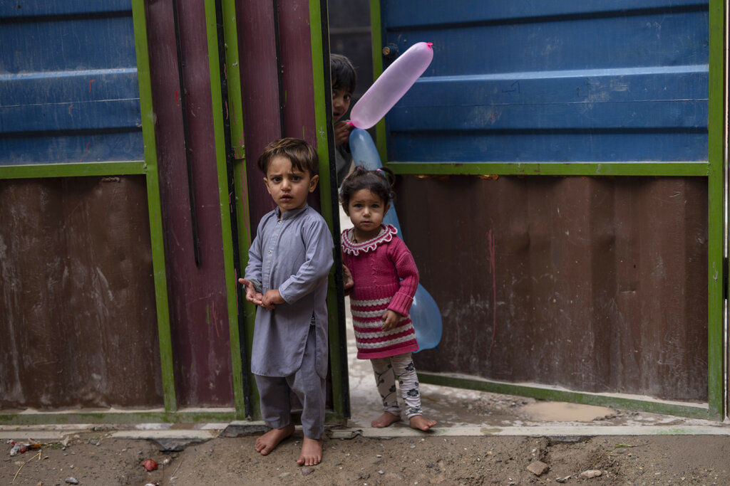 Children stand at the entrance of their house in Herat, Afghanistan, Tuesday, Nov. 23, 2021. (AP Photo/Petros Giannakouris)