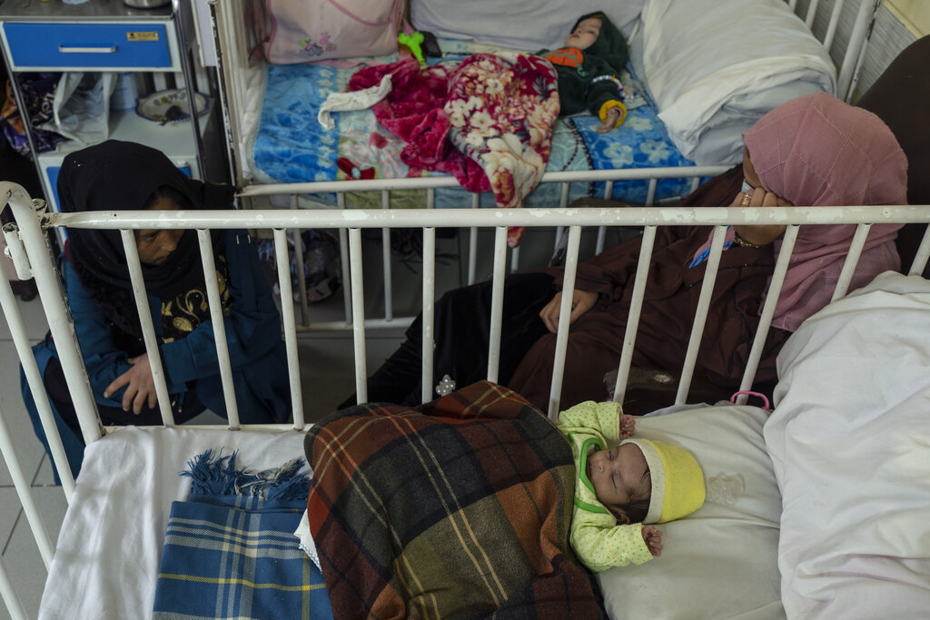 Babies sleep next to their mothers as they undergo treatment at the malnutrition ward of the Ataturk National Children's Hospital in Kabul, Afghanistan, Thursday, Dec, 2, 2021. According to U.N. figures from early November, almost 24 million people in Afghanistan, around 60% percent of the population, suffer from acute hunger, including 8.7 million living in near famine. (AP Photo/Petros Giannakouris)