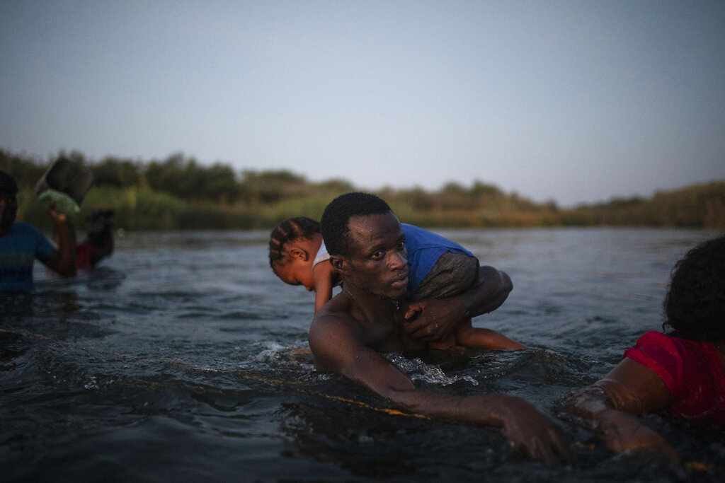 Haitian migrants wade across the Rio Grande from Del Rio, Texas, to Ciudad Acuña, Mexico, on Sept. 19, 2021, to avoid deportation ​to Haiti from the U.S. (AP Photo/Felix Marquez)