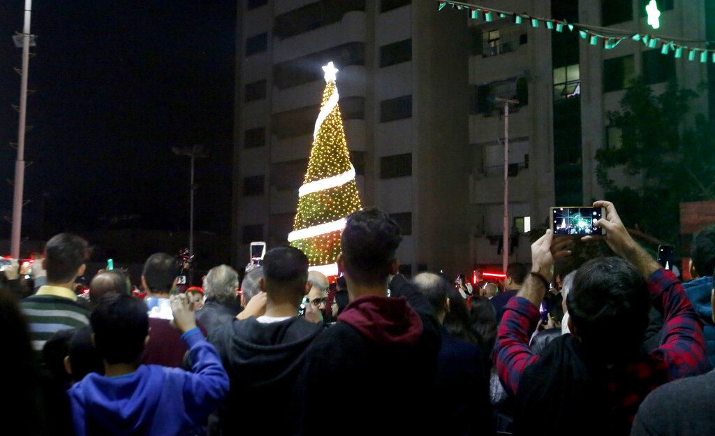 FILE Palestinian Christians attend a Christmas tree lighting celebration in Gaza City, Tuesday, Dec. 3, 2019.  Israeli authorities on Wednesday said they would permit 500 members of the Gaza Strip's tiny Christian community to enter Israel and the occupied West Bank to celebrate Christmas.  (AP Photo/Hatem Moussa, File)