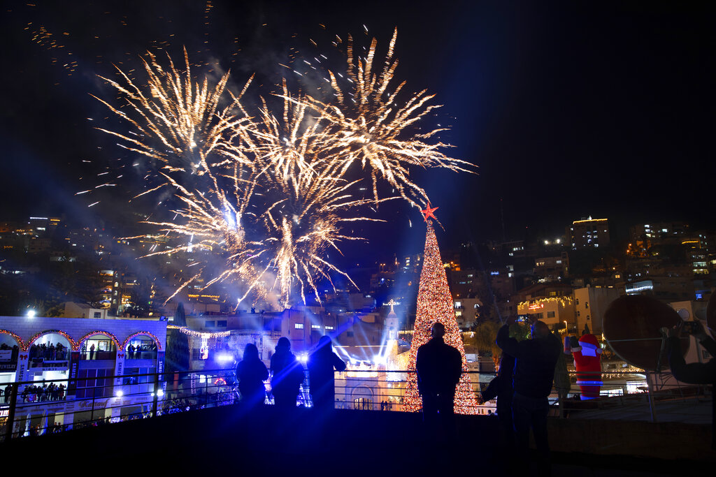 Fireworks burst over the Greek Orthodox Church of the Annunciation, during the Christmas tree lighting ceremony, in Nazareth, Israel, Sunday, Dec. 12, 2021. (AP Photo/Oded Balilty)