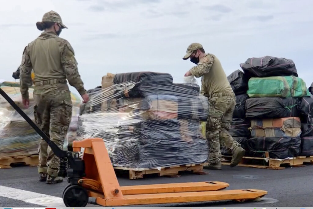 In this photo taken from video, provided by the U.S. Coast Guard and U.S. Navy, personnel offload approximately 11,400 pounds of cocaine and 9,000 pounds of marijuana, with an estimated worth of $211 million, from the USS Gabrielle Giffords in San Diego on Monday, Feb. 1, 2021. (U.S. Coast Guard and U.S Navy via AP)