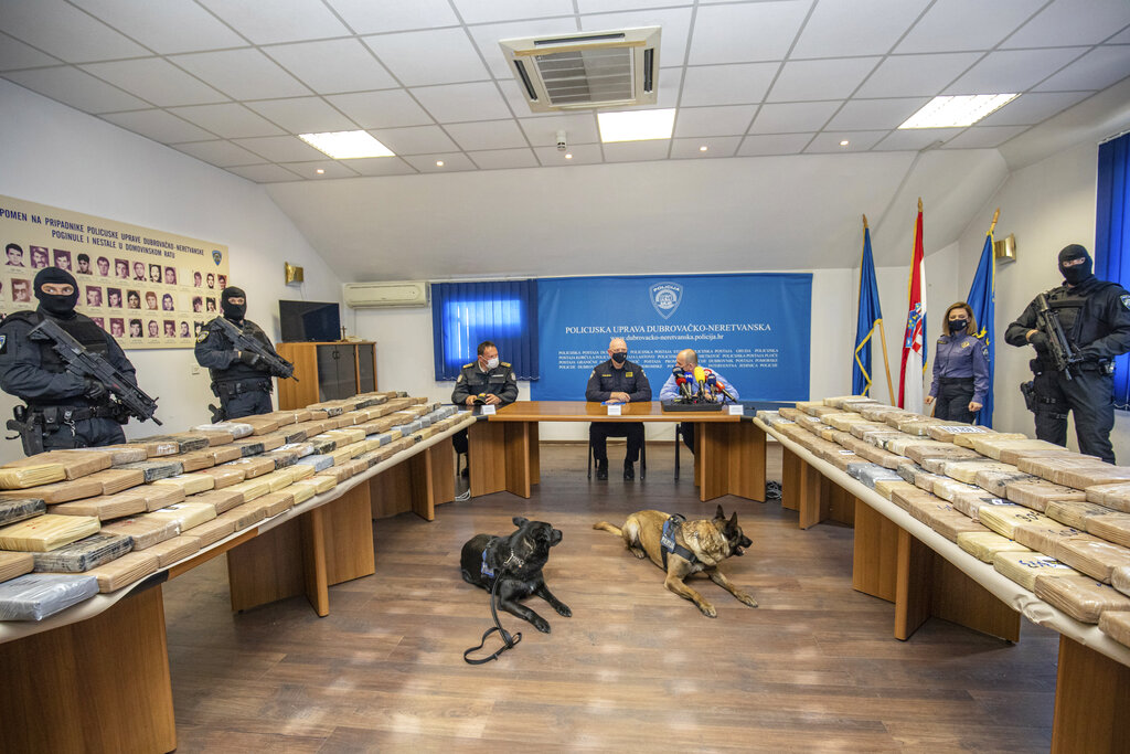 Police officers stand guard next to the packs of cocaine displayed during a news conference at police headquarters in Dubrovnik, Croatia, Wednesday, April 14, 2021. Croatian police say they have seized more than half a ton of cocaine hidden in fruit containers in an Adriatic Sea port. Police said Wednesday the cocaine was discovered two weeks ago in the port of Ploce, near the leading tourist resort of Dubrovnik. (AP Photo)