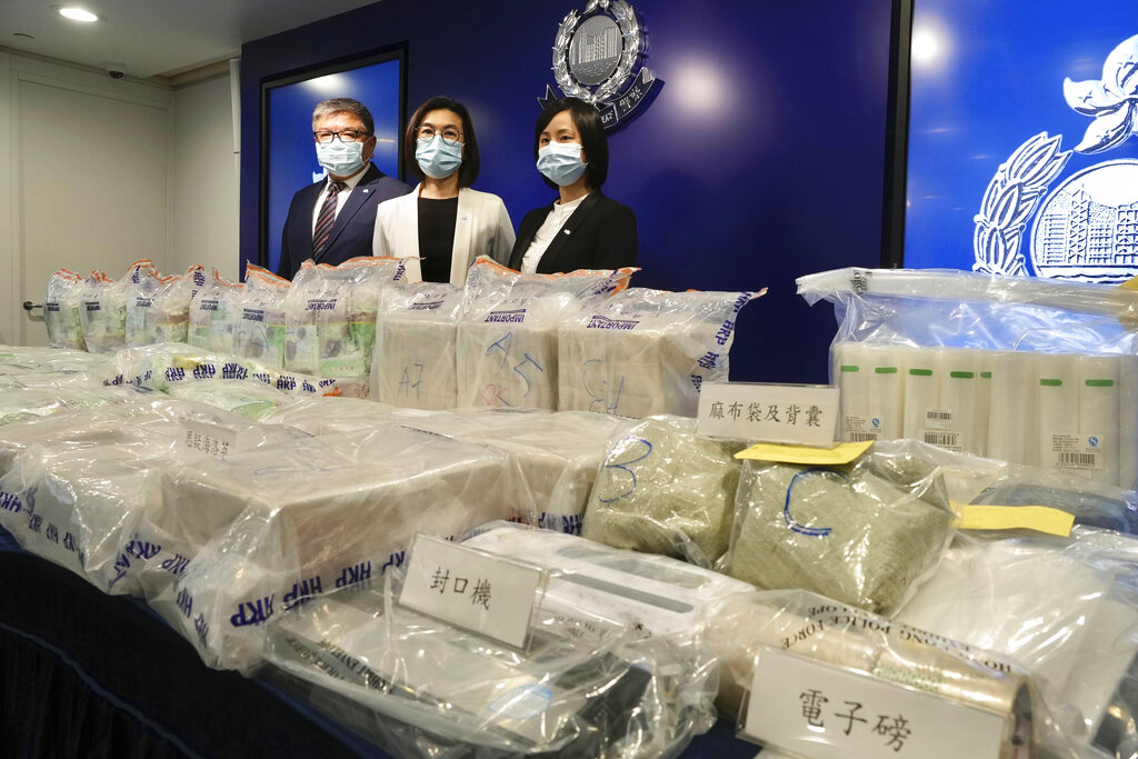 Ng Wing-sze, center, acting chief superintendent Narcotics Bureau and two senior police officials pose with the seized cocaine during a news conference in Hong Kong Thursday, Aug. 19, 2021. Hong Kong police said Thursday that they seized 195 million Hong Kong dollars ($25 million) worth of illegal drugs as part of a monthslong investigation, the largest seizure of the year. (AP Photo/Vincent Yu)